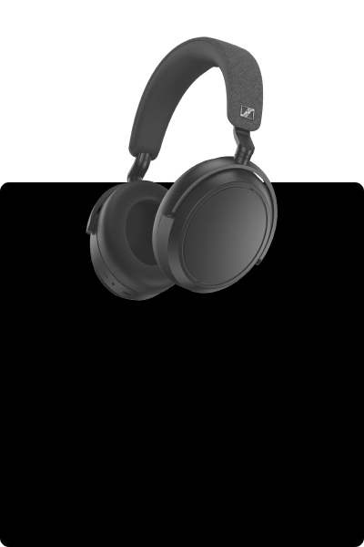 A guy wearing a grey Sennheiser Momentum 4 Wireless Over-Ear Headphones that guarantees a 60 hours battery life every full charge and listens to music on a street.